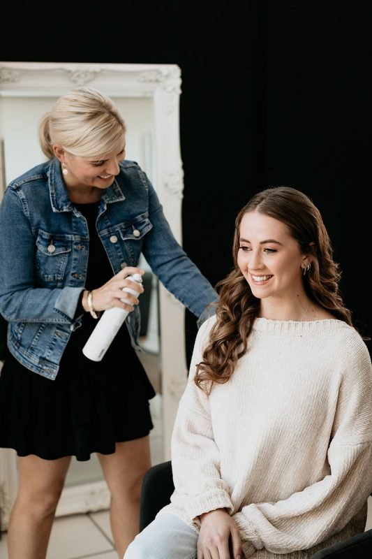 Hairstylist styling the hair of a wedding guest